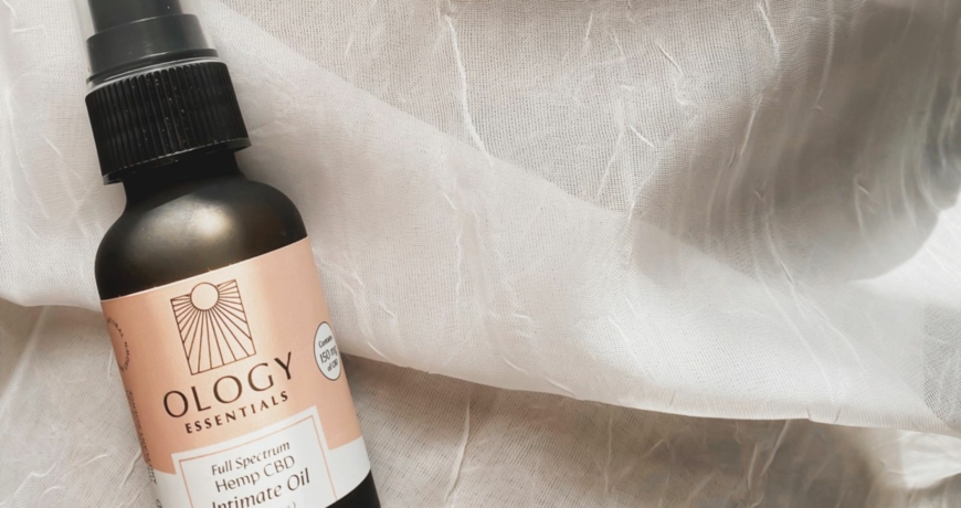Decorative image of Ology Essentials' Intimate Oil on top of a white sheet